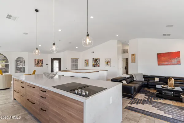 a living room with furniture a large window and wooden floor
