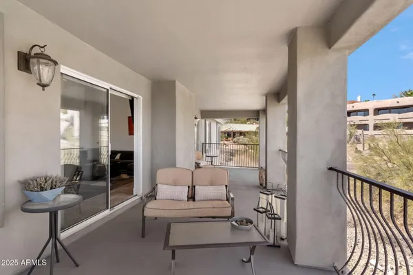 a balcony with chairs and a table