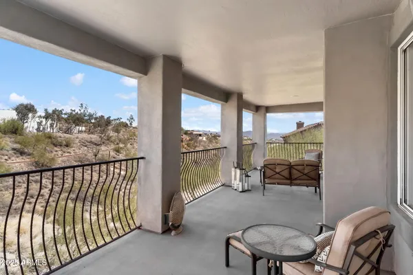 a view of a patio with couches table and chairs with wooden fence