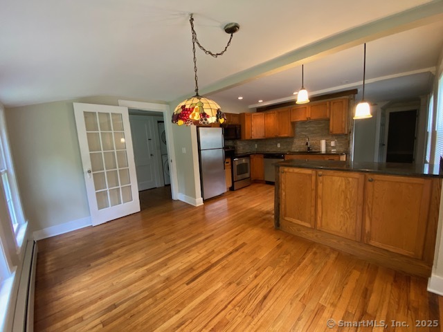 623 Elm Street Monroe, CT 06468 - Photo 7 of 22 a view of a room with wooden floor and a kitchen