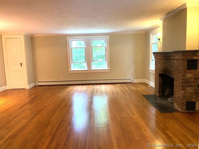 623 Elm Street Monroe, CT 06468 - Photo 10 of 22 an empty room with wooden floor fireplace and windows