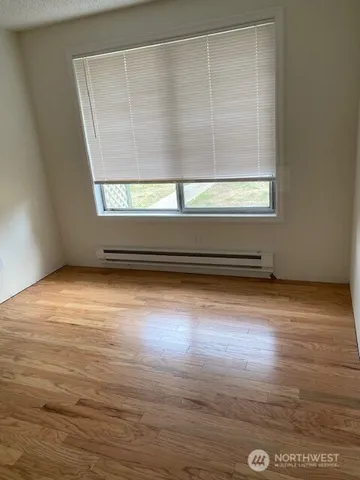 a view of a small space with wooden floor and a window