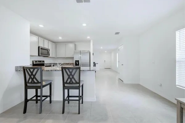 a kitchen with a refrigerator and a dining table