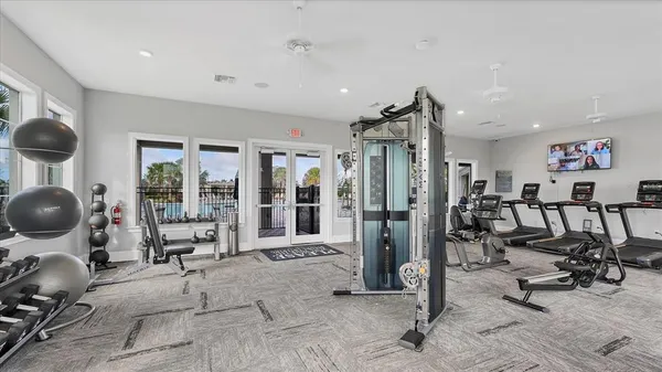 a view of a room with gym equipment and large mirror