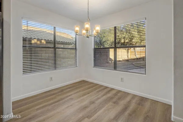a view of an empty room with a window and chandelier