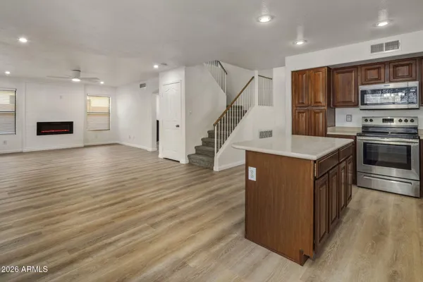a kitchen with stainless steel appliances granite countertop a refrigerator a stove and a wooden floors