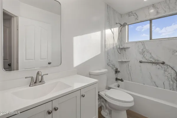 a bathroom with a sink toilet vanity and bathtub
