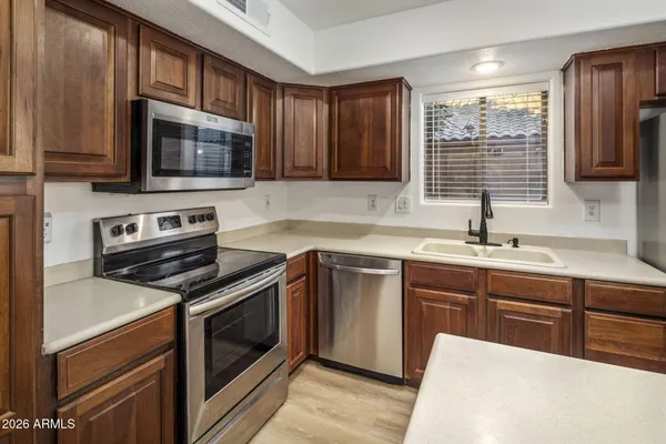 a kitchen with stainless steel appliances a stove microwave and sink