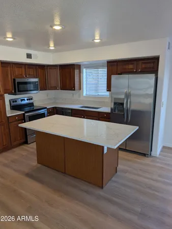 a kitchen with stainless steel appliances granite countertop a stove a sink and a microwave
