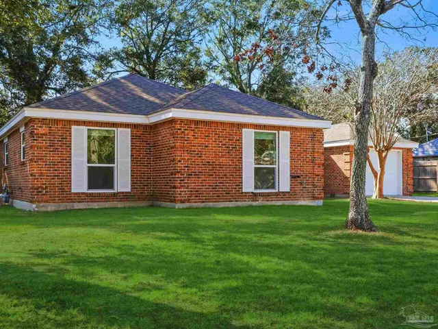 a front view of a house with a garden