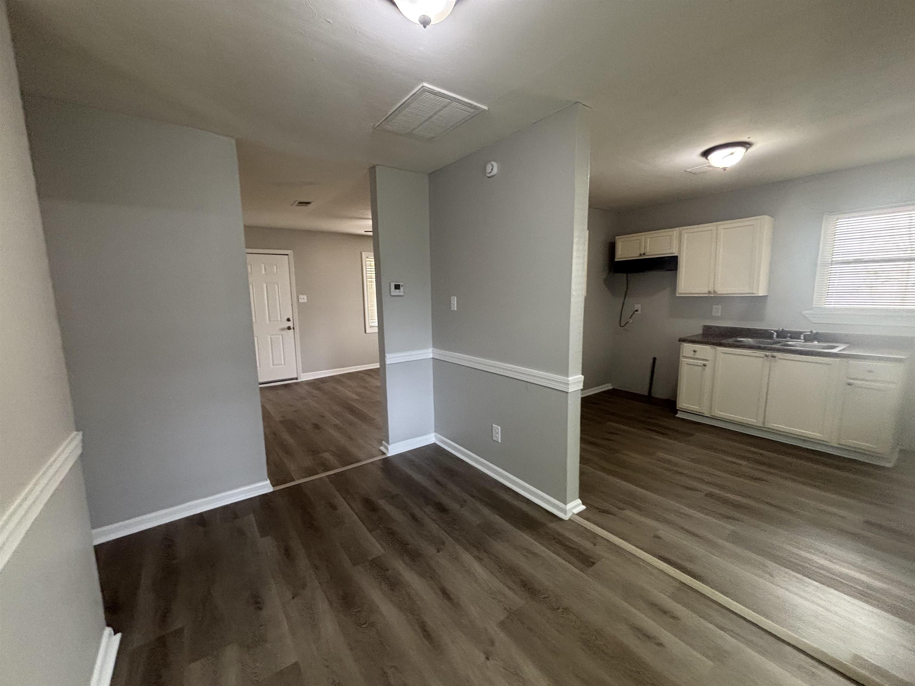 2591 Callie Road Memphis, TN 38127 - Photo 6 of 13 Kitchen area featuring wood-finish flooring, light-toned cabinetry, and a double-basin sink