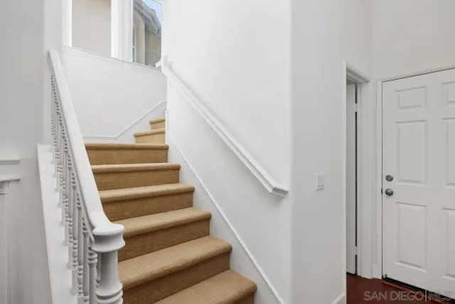 a view of staircase with white walls and a window