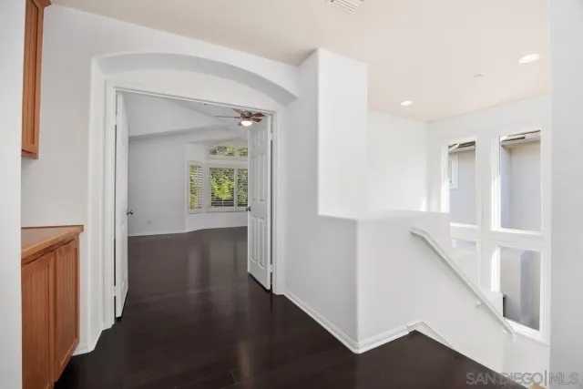 a view of a hallway with wooden floor and stairs