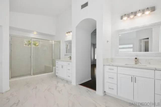 a bathroom with a double vanity sink a toilet and a mirror