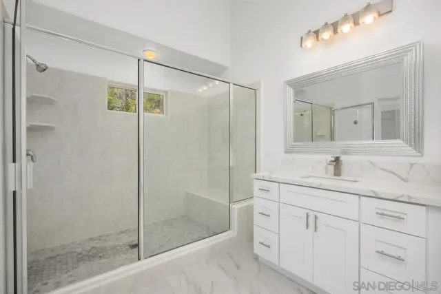 a bathroom with a shower sink and mirror