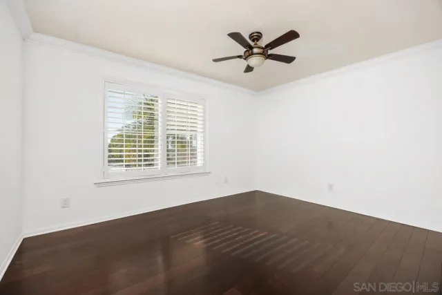 a view of a big room with wooden floor and windows