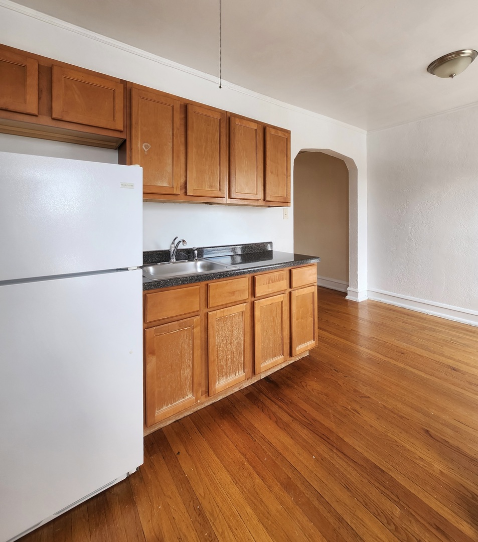 5423 West Montrose Avenue, Unit N3 Chicago, IL 60641 - Photo 4 of 10 a kitchen with stainless steel appliances granite countertop a refrigerator a sink dishwasher a stove with wooden floor
