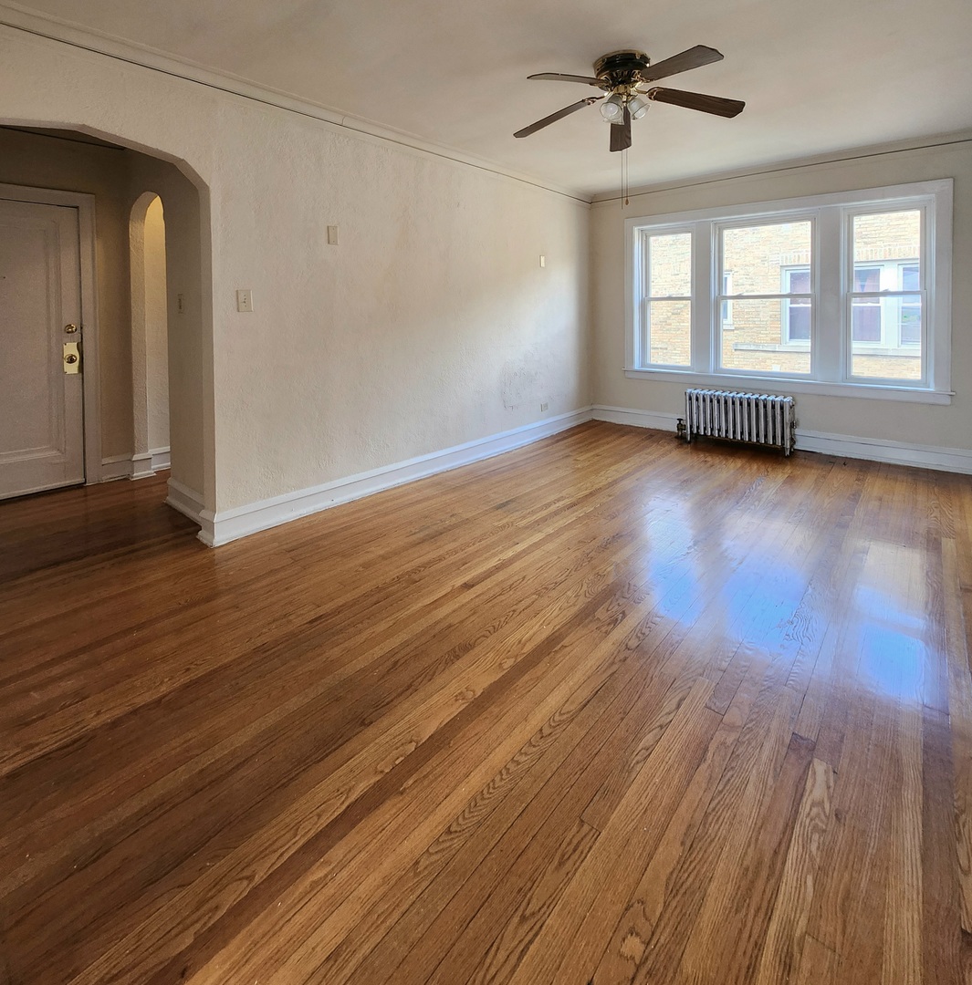 5423 West Montrose Avenue, Unit N3 Chicago, IL 60641 - Photo 8 of 10 an empty room with wooden floor and windows