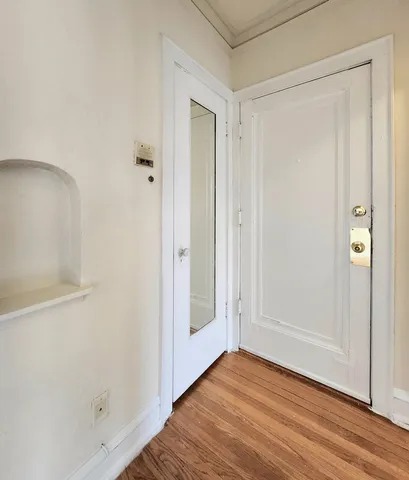 a view of an empty room with wooden floor