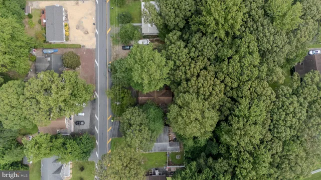 an aerial view of residential house with outdoor space and trees all around