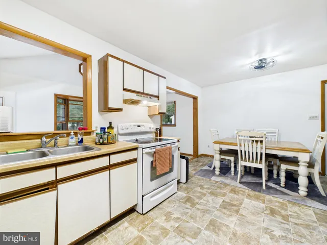 a kitchen with stainless steel appliances a stove a sink and white cabinets
