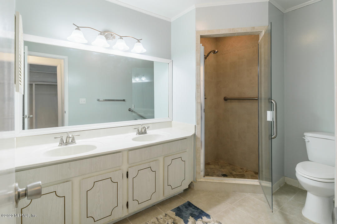 2233 Seminole Road, Unit 30 Atlantic Beach, FL 32233 - Photo 18 of 29 a bathroom with a toilet a sink a mirror and a shower