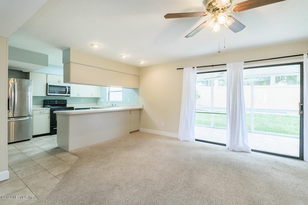 2233 Seminole Road, Unit 30 Atlantic Beach, FL 32233 - Photo 10 of 29 a kitchen with stainless steel appliances kitchen island granite countertop a refrigerator and microwave