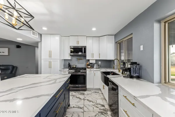 a kitchen with kitchen island granite countertop a sink dishwasher stove and refrigerator with wooden floor
