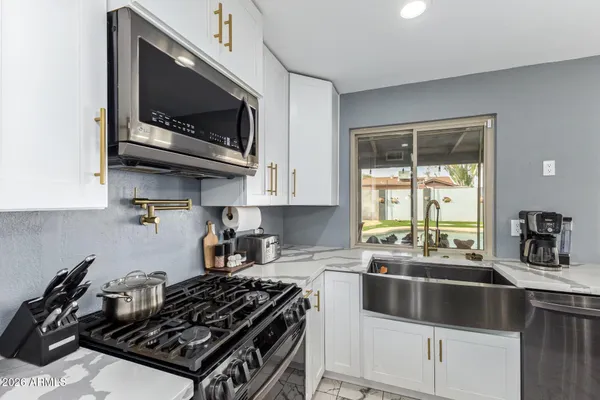 a kitchen with a stove a sink and a microwave