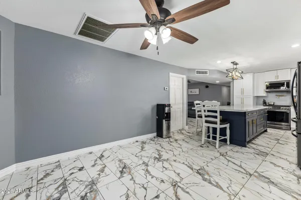 a bedroom with a bed chandelier and a view of kitchen