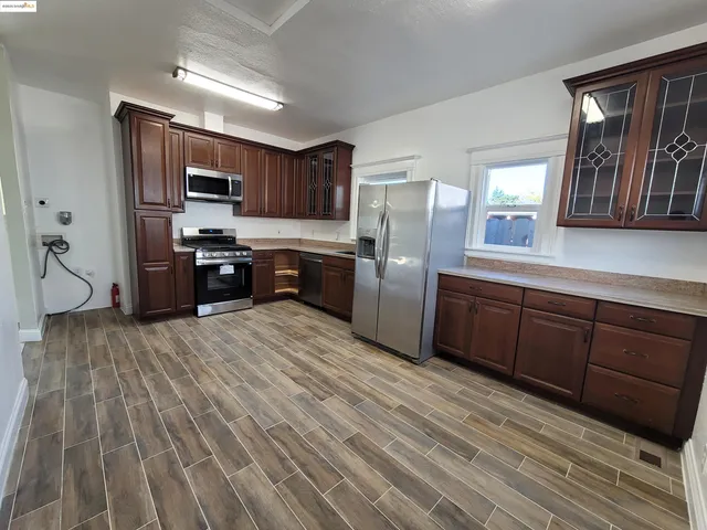 a kitchen with stainless steel appliances a refrigerator sink and wooden cabinets