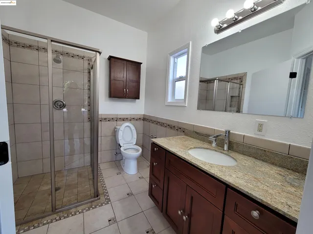 a spacious bathroom with a granite countertop sink mirror and shower