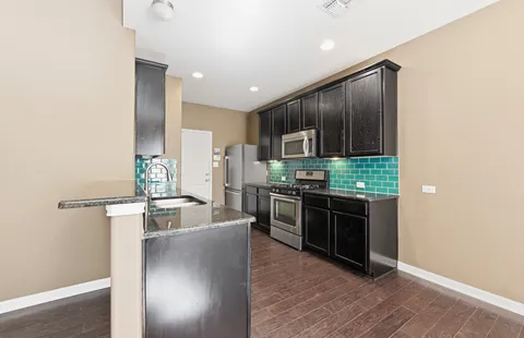 a kitchen with stainless steel appliances granite countertop a refrigerator stove and oven
