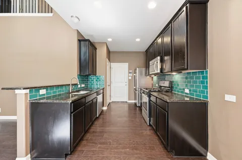 a large kitchen with stainless steel appliances granite countertop a stove and a sink