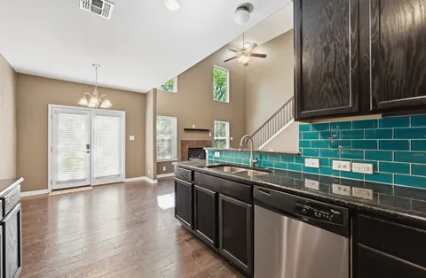 a kitchen with stainless steel appliances granite countertop a sink and wooden cabinets