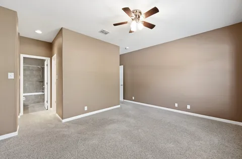 an empty room with a ceiling fan and a window