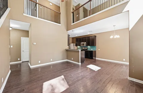 a view of a kitchen with kitchen island wooden floor and stainless steel appliances