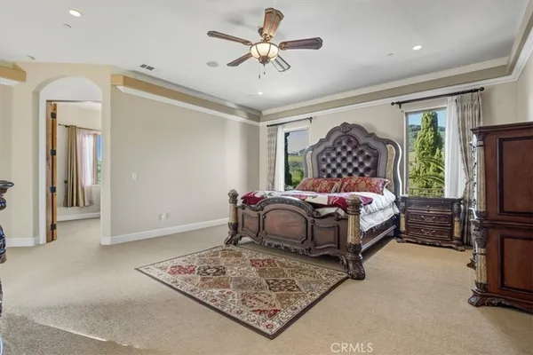 a spacious bedroom with a bed and a chandelier