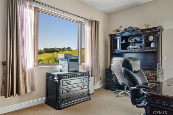 a bed sitting in a spacious bedroom next to a window