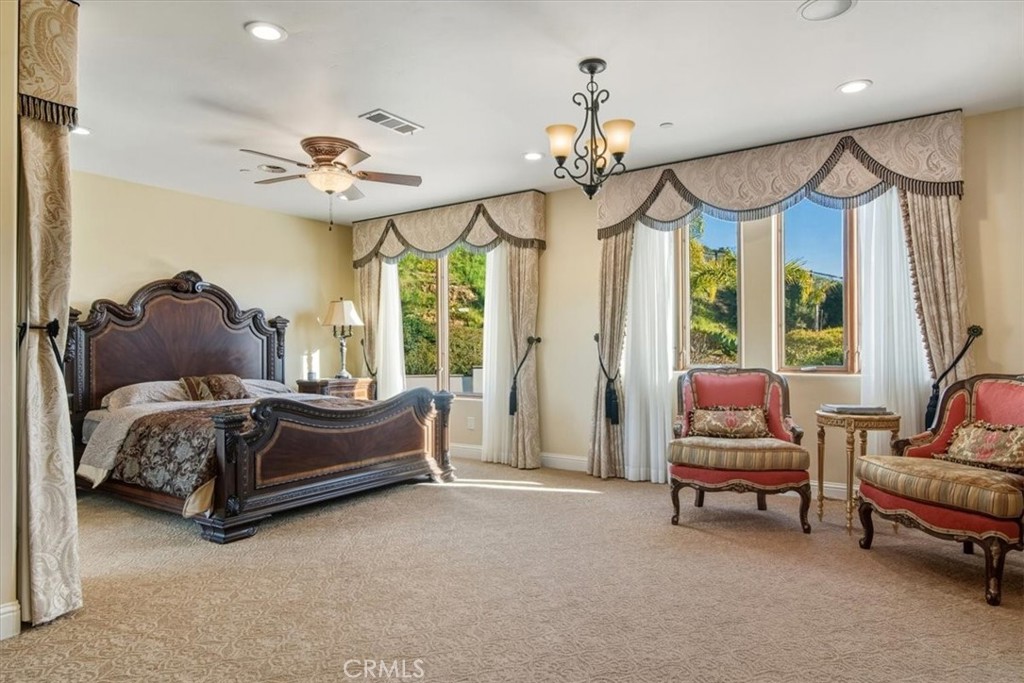 775 Riata Lane Nipomo, CA 93444 - Photo 20 of 48 a spacious bedroom with a bed and a chandelier