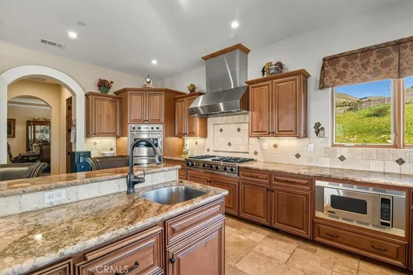 a kitchen with wooden cabinets and a stove top oven
