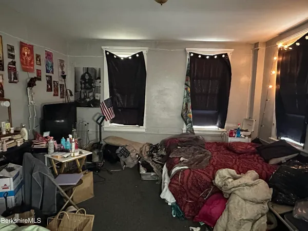 a bedroom with a bed gym equipment and a flat screen tv