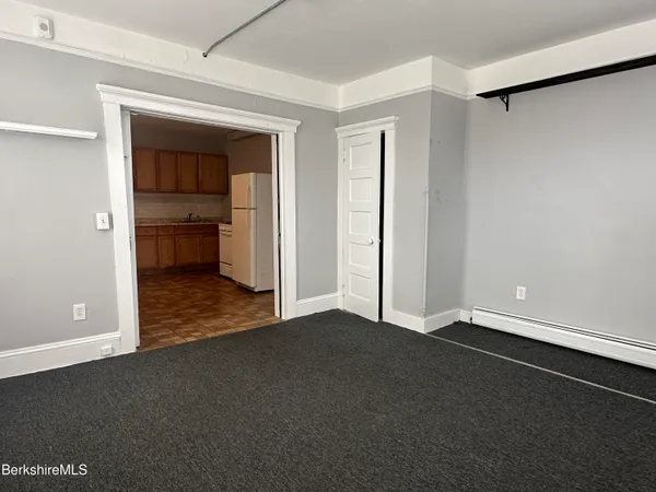 a view of an empty room with closet and a window