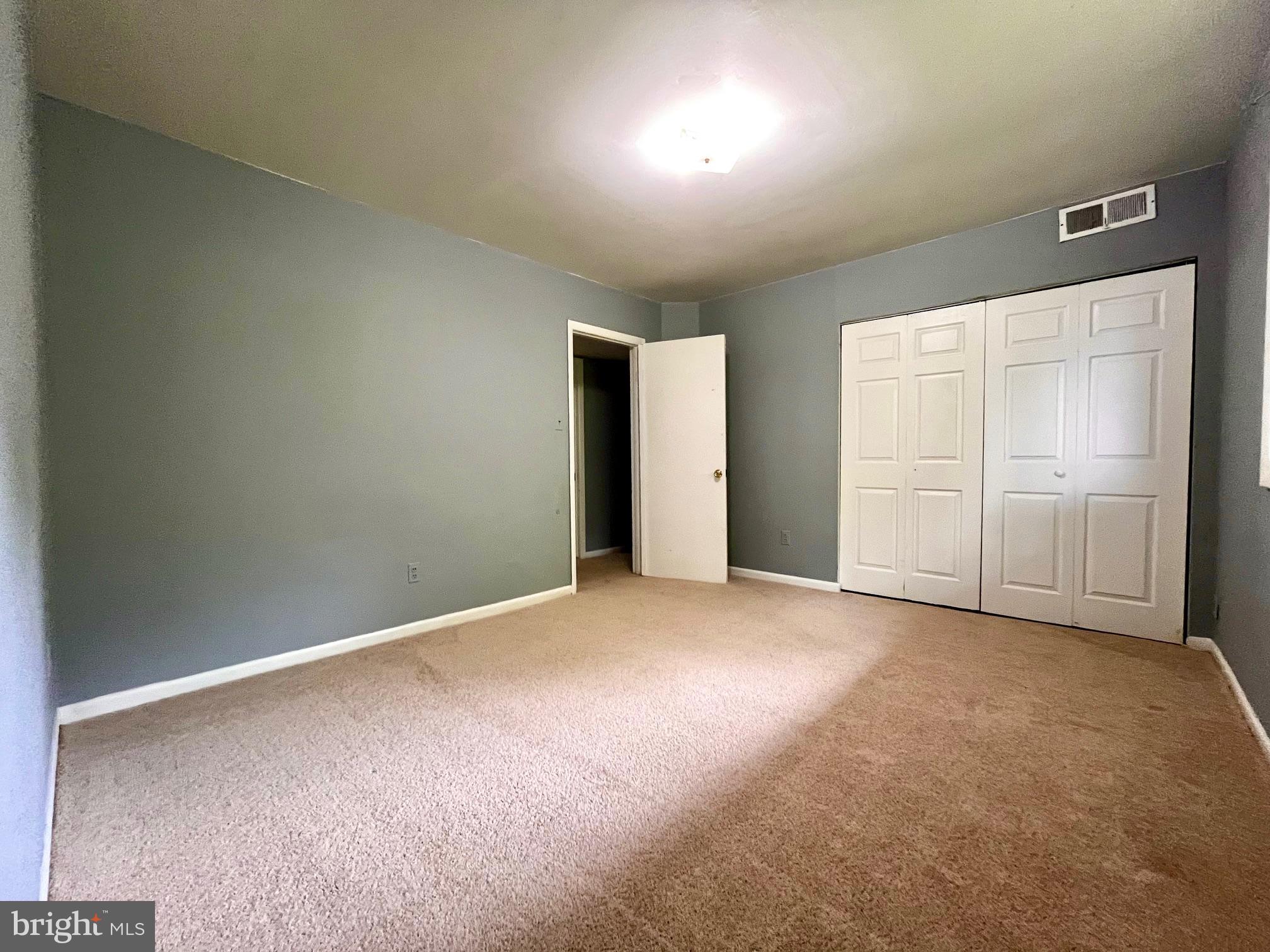 3138 Brinkley Road, Unit 8303 Temple Hills, MD 20748 - Photo 14 of 18 an empty room with closet and wooden door