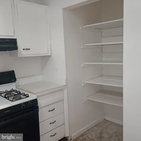 a kitchen with white cabinets and appliances