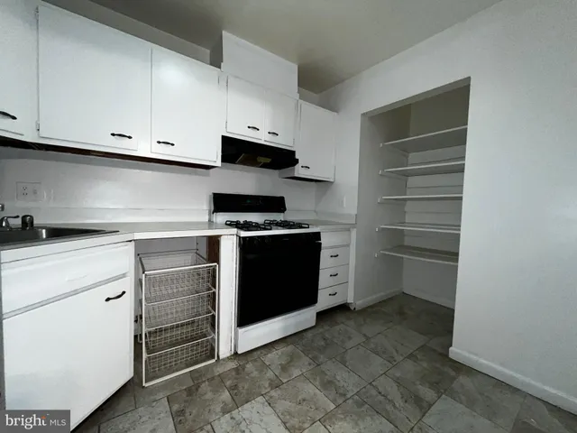 a kitchen with a stove and white cabinets