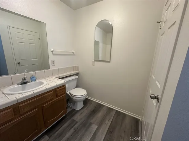 a bathroom with a granite countertop toilet and sink