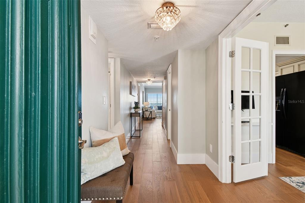 1586 Gulf Boulevard, Unit 2502 Clearwater Beach, FL 33767 - Photo 11 of 47 a view of a hallway with wooden floor windows and livingroom
