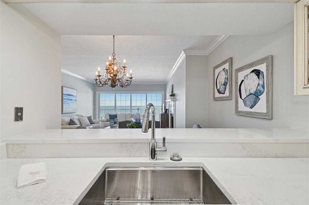 1586 Gulf Boulevard, Unit 2502 Clearwater Beach, FL 33767 - Photo 20 of 47 a kitchen with a sink and a chandelier