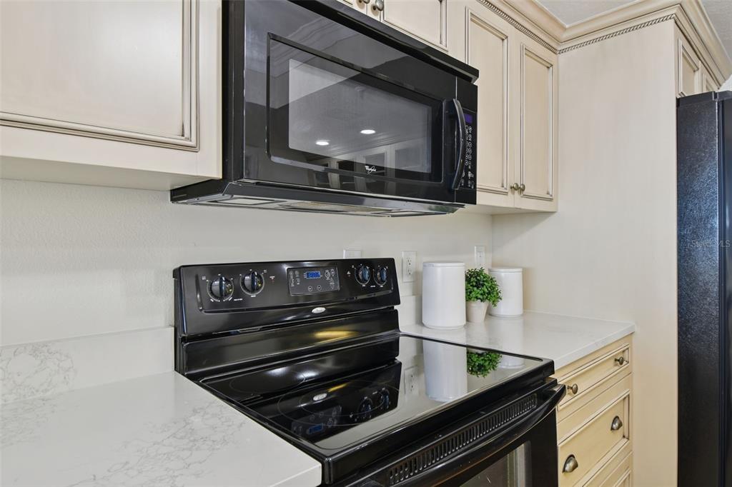 1586 Gulf Boulevard, Unit 2502 Clearwater Beach, FL 33767 - Photo 21 of 47 a stove top oven sitting inside of a kitchen